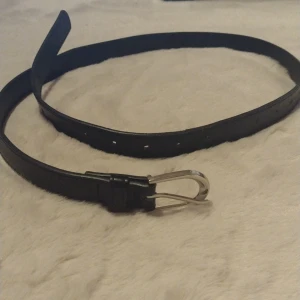 Svart skärp 95cm - Svart skärp/bälte i 95cm. Helt okej skick, köpt på hm för ca 3år sen runt 100kr (?). Säljer för 20kr + frakt 