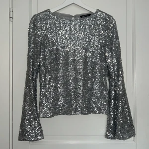 Paljettopp - Silvrig paljettopp från Gina Tricot i strl s. Oanvänd med prislappen kvar. 