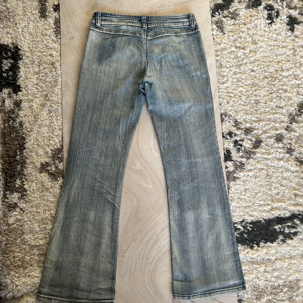 Lågmidjade bootcut y2k jeans med cool design på fickorna 10/10. skick midjemått 41cm rakt över. Innebensläng 81cm. Farkut & Housut.