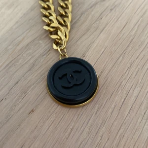 Chanel upcykling halsband  - Äkta knapp fr Chanel satt på kedja i metall. Mässingsfärgad(oklart material kedja. Upcykling köpt i Paris. Halsband 