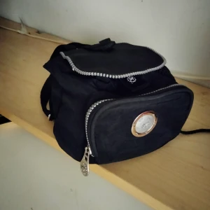 Liten behändig ryggsäck. - Liten men rymlig ändå med plats för det mesta man behöver ha med sig. Ser oanvänd ur men jag tror att den amvändes ett öar gånger. I skick som ny.