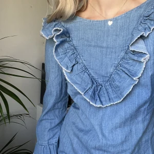 Jeansklänning mini med volang från Zara - Säljer nu denna otroligt söta jeansklänning med volanger runt halsen då den inte kommer till användning. Trots att det är denimtyg är materialet relativt tunt, så den passar även de varmaste sommardagarna.☀️