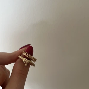 Ringar - Två guldfärgade ringar. 35 st eller båda för 55kr.  Ormringen är från Gina i storlek M. Den andra är mindre i storleken kanske S.