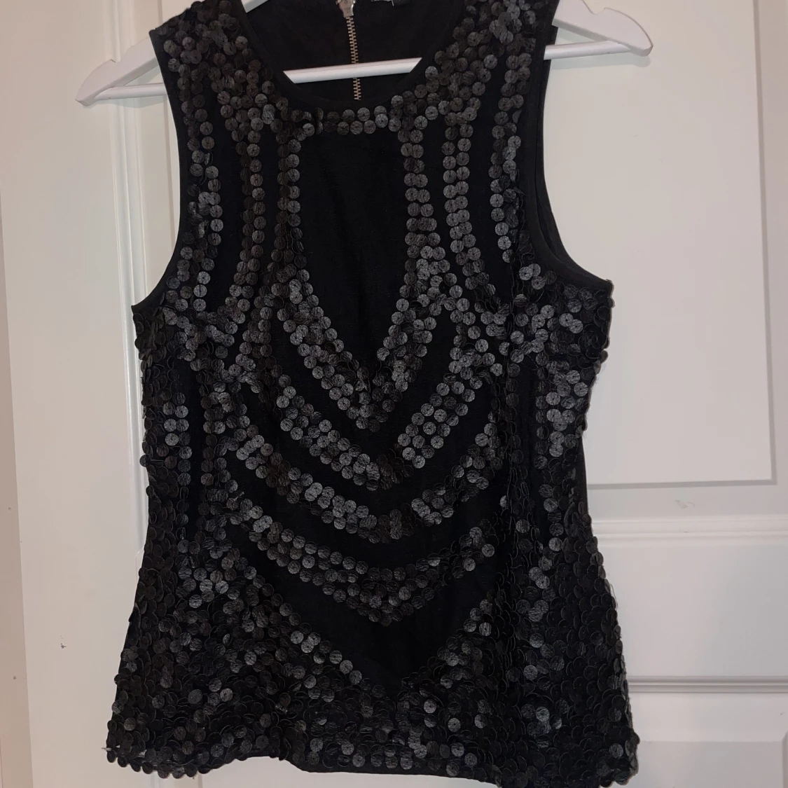 Svart top med läder liknande detaljer