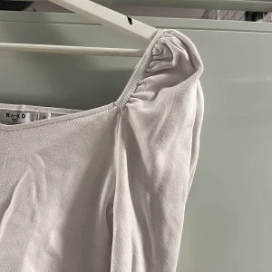 Topp - Topp med puffärm, strl xs från NA-KD.