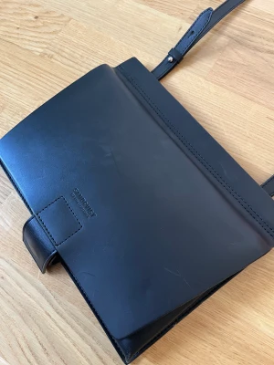 Exklusiv väska från Sandqvist  - Limiterad axelremsväska från Sandqvist i vegetabiliskt garvat läder (hållbart & åldras fint). Köpte den när jag jobbade för varumärket, använd 1 gång. Justerbar axelrem som går att ta av/byta ut. Några ytliga märken i lädret men i mycket gott skick!  