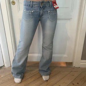 Lågmidjade jeans - Så så snygga lågmidjade bootcutjeans i ljus tvätt🤩 Galet snygg design med små fickor framtill och endast en bakficka. Helt i nyskick med lappar kvar. Skriv vid funderingar och kolla in mina andra annonser💗
