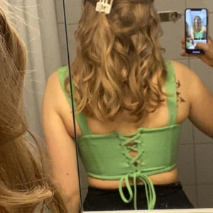 Supersnygg grön korsettopp - Säljer nu min fantastiska gröna korsettopp då det blivit för liten.. i mycket gott skick utan skavanker!