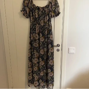 Blommig klänning - En superfin blommig klänning som tyvärr inte passade som jag önskade. Den har en slit vid benet och är i bra skick!!