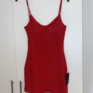 En röd klänning i ribbat material. Aldrig använt då den är för liten och lappen är kvar☺️ 