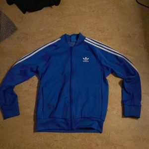 Blå adidas tröja - Säljer En blå adidas zip tröja pga brist på användning.
