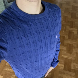 Kabelstickad Morris Tröja - En perfekt elegant tröja till vintern. Modellen i bilden är 178Cm. Skicket på tröjan är 9/10 utan några defekter vilket är varför du kan köpa den för bara 499kr kontra originalpriet som ligger på 1299kr.