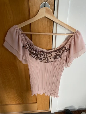 VILA, blus med paljett-detaljer - VILA, blus i plisserat format med fina paljett-detaljer i blom-mönster, färgen är gammaldags rosa, storlek: S, material: 100% polyester.