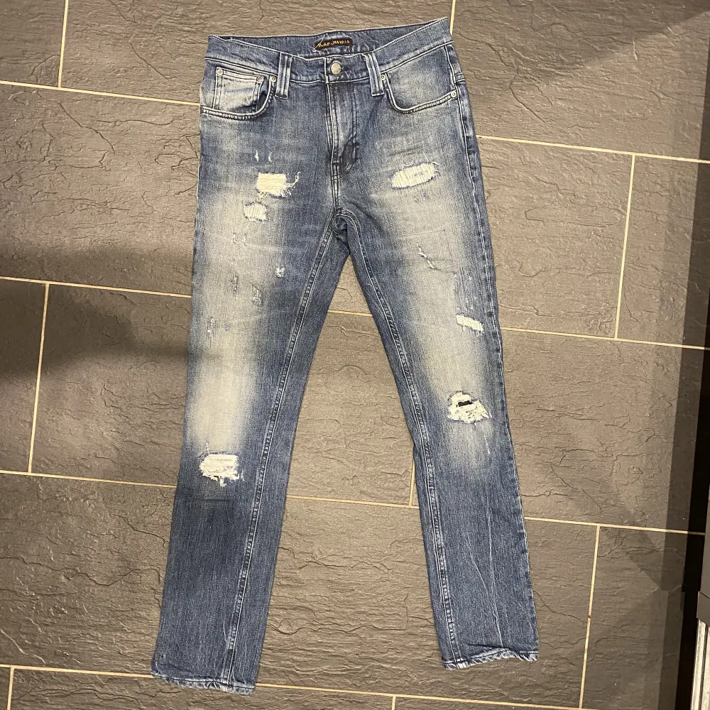 Ett par riktigt fräscha nudie jeans i perfekt skick.   Storlek: 30/32.   Modell: Tape ted.   Passform: Slim fit.  Nypris:1400.   Vårat pris: 649. . Jeans & Byxor.