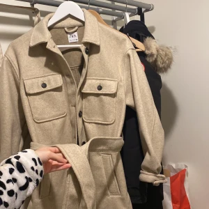 Kappa från zara  - Den är i storlek xs, färg beige. Jätte fin inga som helst fel, endast en liten läppstifts fläck vid armen som Knappt syns