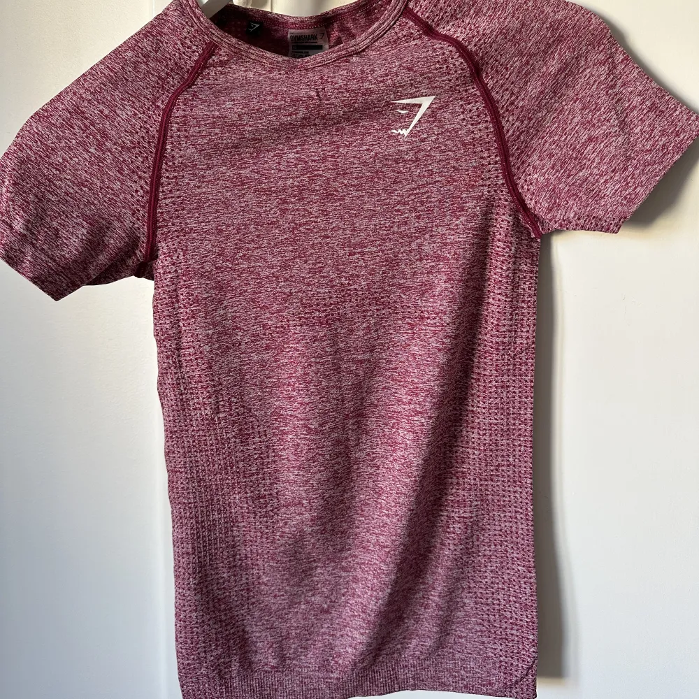 Gymshark T-shirt vinröd, säljes pga fel storlek knappt använd väldigt fint skick. T-shirts.