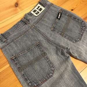 Supersnygga Straight lågmidjade jeans från Detroit med tryck där bak, använda fåtal gånger, midjemått tvärsöver:35cm och innerbenslängd:72cm