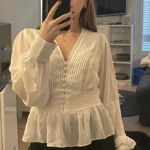 Vit blus - En supersöt blus som passar storlek xs-s. Resår i midjan. Köpt second hand och märke okänt