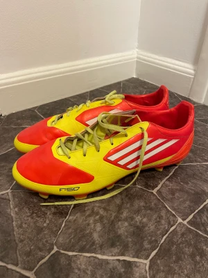 Adidas F50 fotbollsskor  - Fina adidas f50 gamla goa klassiker.Tro mig ni kommer va som Messi på planen med dessa sköningar Saknar tyvärr in sula pga de gamla va för ofräscha. Överlag jäkligt bra kvalite, inge större slitage på skorna. Kan användas på naturgräs men gjorda för konst
