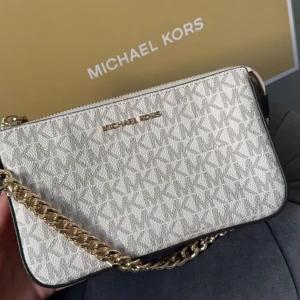 Michael kors Jet set chain pouchette - Väskan är köpt för ordinarie pris i Michael Kors butiken. Säljes då den inte kommer till någon användning. Är i toppskick och har endast använts några gånger. Kommer med låda.