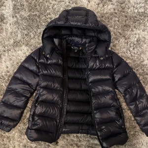 Ralph Lauren Jacka storlek 140 - Säljer en Ralph Lauren jacka i fint skick utan några defekter. Jackan är i storlek 140 och är mörkblå