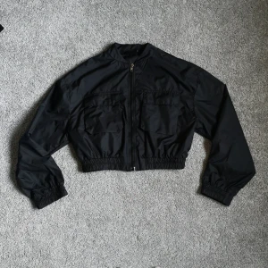Bomberjacka svart - En supersnygg svart croppad (lite tunnare) bomberjacka från tally weijl i storlek M. Är i nyskick. 