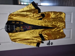 Kimono  - Gul/svart kimono,  har tyvärr tappat bort "bältet". Den har två sidor,  går att använda båda sidorna, vändbar.   