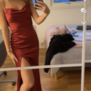 Röd satinklänning   - Vinröd balklänning i satin med slits vid benet och korsad rygg. Använd en gång på balen. Väldigt bra skick. och bra material. Storlek S. Nypris 899kr. 