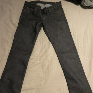 Gråa straight leg jeans - Mörkgråa raka jeans med låg midja och mönster på fickorna. Köptes second hand i väldigt bra skick utan defekter, men tyvvär för små på mig så har inte kunnat använda dem:( Skulle tro att passformen är någonstans mellan S/M