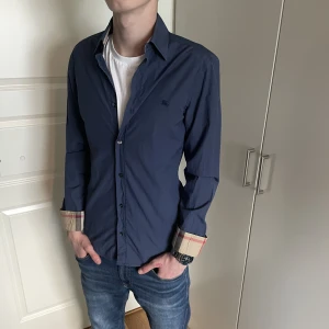 Burberry skjorta  - Säljer en burberry skjorta som är i väldigt bra skick! Den är i en väldigt fin blå färg m!  Hör gärna av dig om du har frågor!