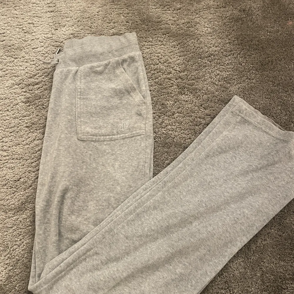 ljus gråa juicy byxor som är i väldigt bra skick förutom att ena metall saken har ramlat av vid snörena. Jeans & Byxor.