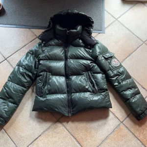 Moncler Himalaya grön - Säljer denna Moncler Himalaya jacka köpt från kaspersheat. Den är i bra skick förutom att cartoonen inuti jackan trillat av. Jag har kvar den så man kan sy på om man vill. Förutom det är jackan felfri. Kvitto finns. Jackan passar S/M