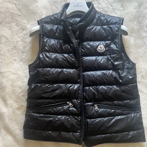 Moncler väst - Moncler gui väst i svart, storlek 3. Sparsamt använd men ändå använd Sitter som medium. Finns tags samt dustbag. Köpt på manofakind så hittar tyvärr inte kvittot, Nypris 6000