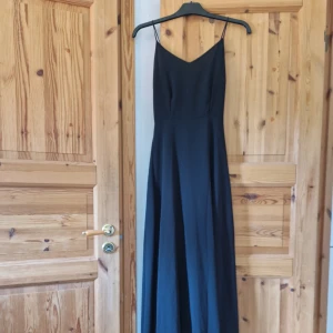 Hellång svart klänning - Hellång (till 180cm) svart klänning. Underklänning når ner till mitten av låren. Den har två slitsar i varje sida. 