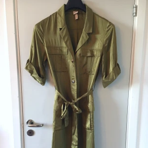 Olivgrön skjortklänning  - En snygg skjortklänning som knyts i midjan  Silkig i tyget   Mycket fint skick 