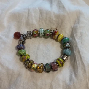 Armband  - Säljer detta superfina och unika armband. Det är i nyskick utan skavanker/defekter. Det går att mixa och placera om de 21 pärlor/berlocker på hundratals olika sätt. Väldigt unikt och vackert. Det går givetvis bra att bara bära några pärlor åt gången. 