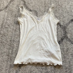 Vitt linne - Ett vitt linne med en jätte fin vit spets, tröjan är v-ringad och är så sjukt fin!💘💘