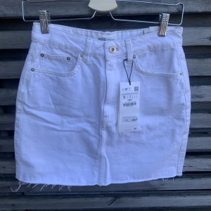 Jeanskjol från Zara - Vit jeanskjol från Zara i strl S. Helt ny med lappar kvar! 34 cm bred i midjan. OBS jag kan inte skicka några bilder med den på, då den inte passar mig. Köparen står för eventuella fraktkostnader. 