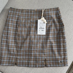 Rutig minikjol S - Säljer denna oanvände minikjolen från Pull&Bear. Köpt för 199 kr Säljer för 100