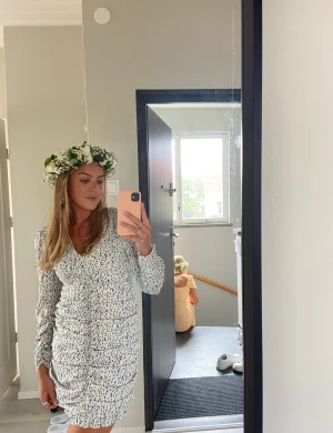 Midsommarklänning - Vit klänning med små blå blommor. Perfekt till midsommar. Storlek xs, men stretchig, kan passa upp till storlek m. Frakt tillkommer. 