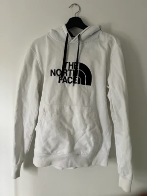 The North Face Hoodie vit - Säljer nu min vita The north face hoodie pågrund av att den är för liten. Den är i ett bra skick och passar både för ngn med M och L då den är lite större i storleken.