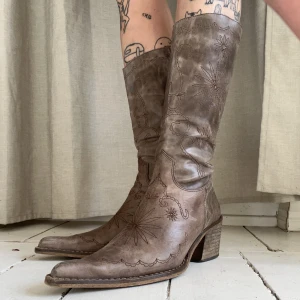 Läderstövlar cowboyboots  - Spetsiga stövlar i cowboystil. Subtilt mönstrade med sömmar, bekväma att gå i. Nästintill oanvända i jättebra skick. Sitter som en smäck!