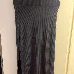 Snygg mörk grå lång kjol med en slits! Aldrig använd! Frakt kostar 65kr!! 