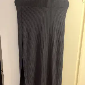 Snygg mörk grå lång kjol med en slits! Aldrig använd! Frakt kostar 65kr!! 