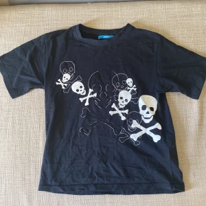 Dödskalle t-shirt - Fin dödskalle tröja som är lite mindre, ( inte direkt som en baggy t-shirt ). Passar mig jätte bra som är S/XS. Den skulle nog passa någon som var lite större som en baby tee men fungerar självklart såhär också. Köparen står för frakt, märke: ?