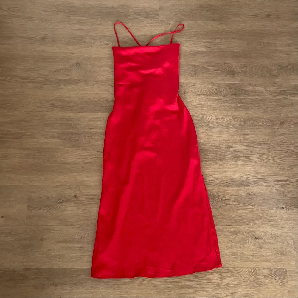 Röd klänning av den längre modellen med knytningsdetaljer i ryggen och slits vid ena benet. Helt oanvänd ❤️. Klänningar.
