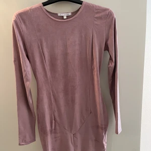 Mockaklänning - Tight tunn klänning i mockaimitation. Färgen är dov ljusrosa. Aldrig använd!