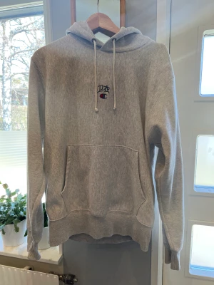 Champion-hoodie, Japanese script M - Snygg, ljusgrå ovanlig Champion-hoodie, ”Japanese Script”. Storlek M. Kan hämtas på Ekerö eller skickas. 