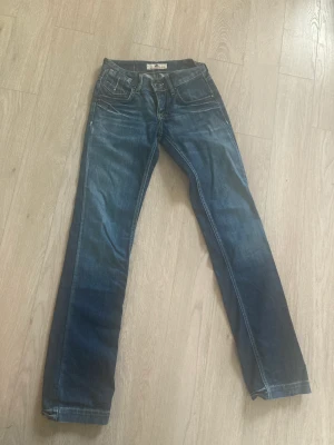 Vintage jeans - Ett par vintage lågmidjade jeans ifrån ett okänt märke med straight leg. Midja: 35 cm och längden passar någon mellan 165-170