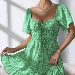 Blommig grön klänning i storlek L 